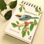 Imagen ambientada de una libreta argollada de Objetos Poéticos con el diseño de la Tángara Rastrojera