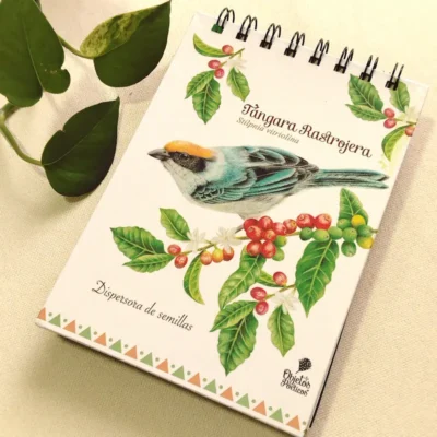 Imagen ambientada de una libreta argollada de Objetos Poéticos con el diseño de la Tángara Rastrojera